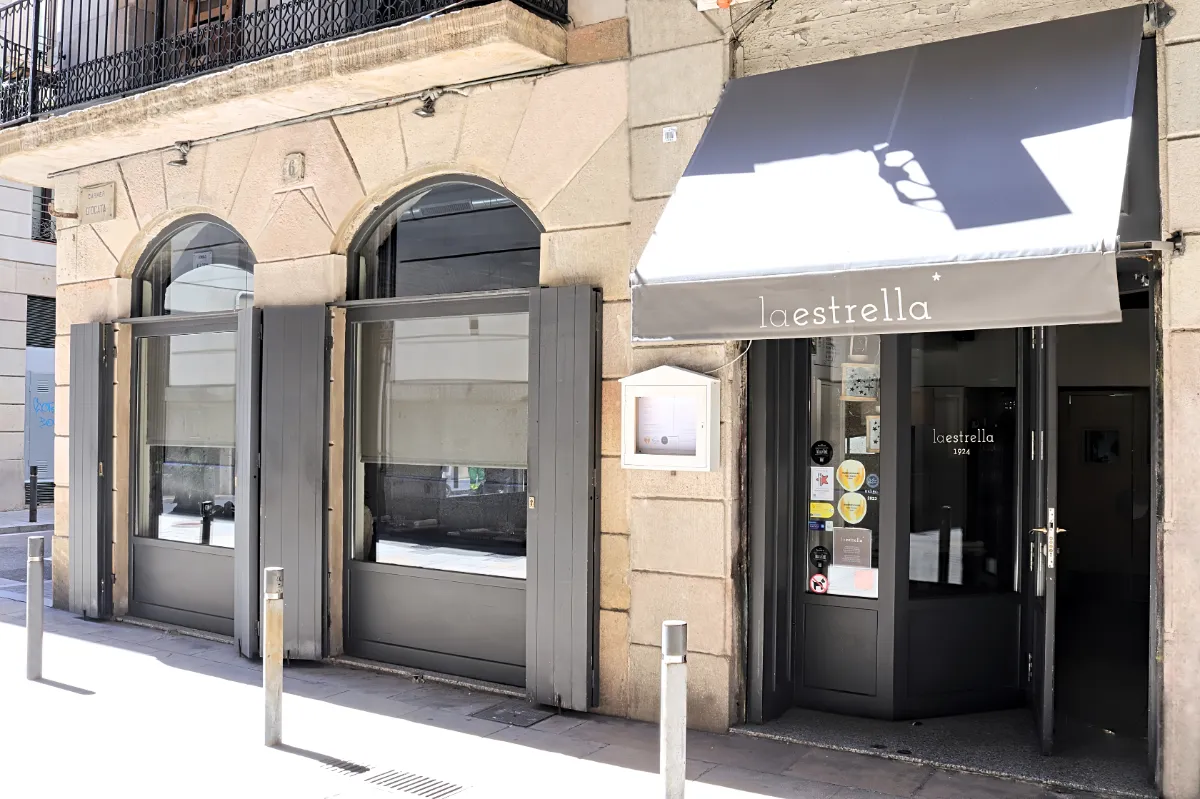 Fachada del Restaurante La Estrella 1924 con su toldo gris en el Carrer d'Ocata, 6, en El Born, Barcelona